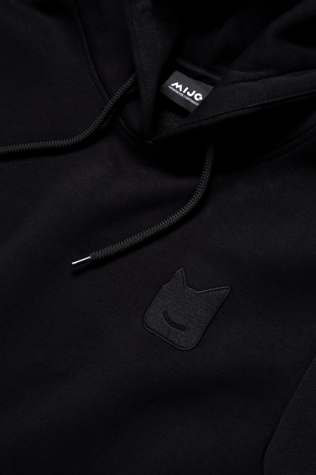 gesticktes Logo auf einem schwarzen Hoodie von mijo. Corporate Fashion.