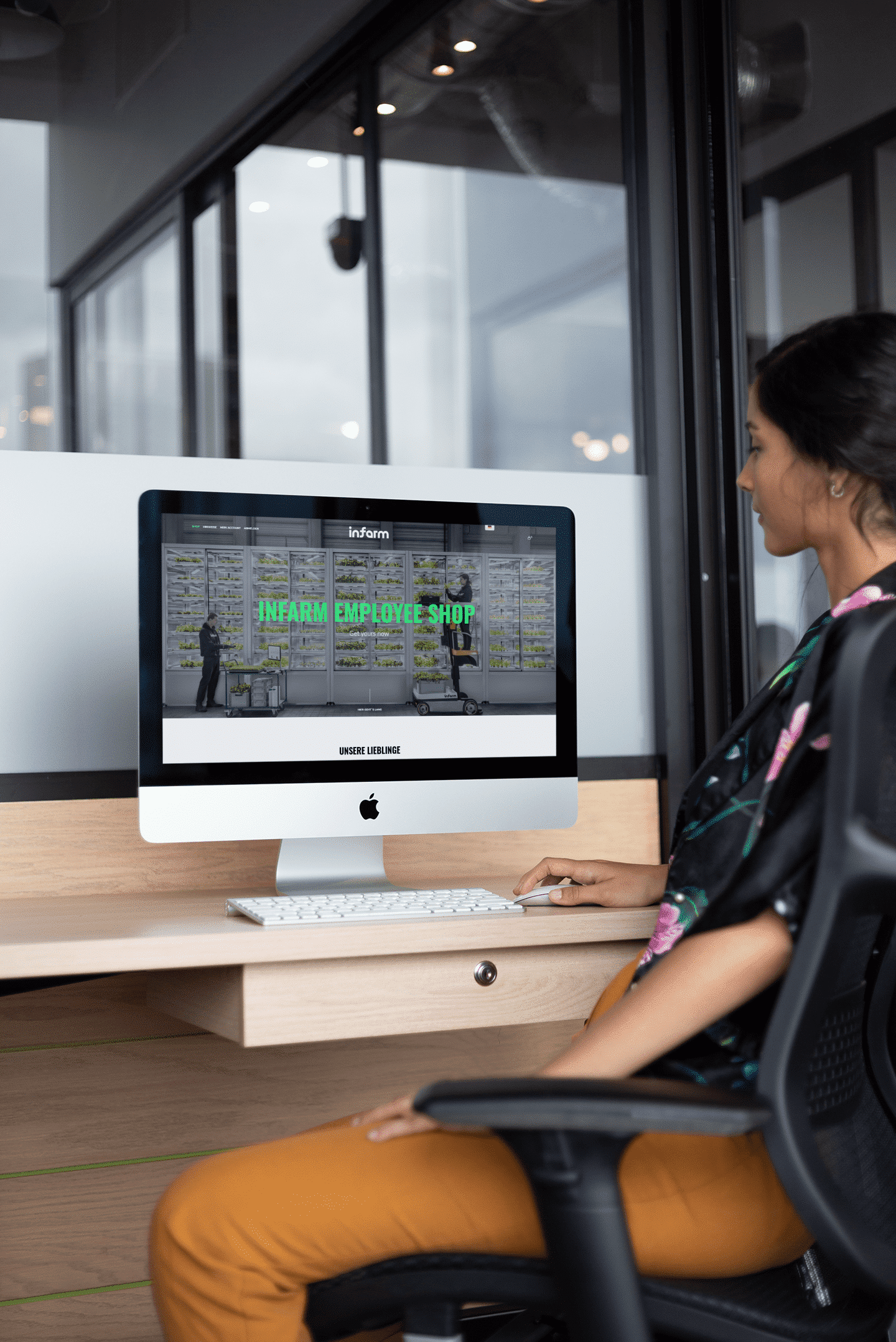 woman-working-on-an-imac-mockup-on-a-wooden-desk-a21170